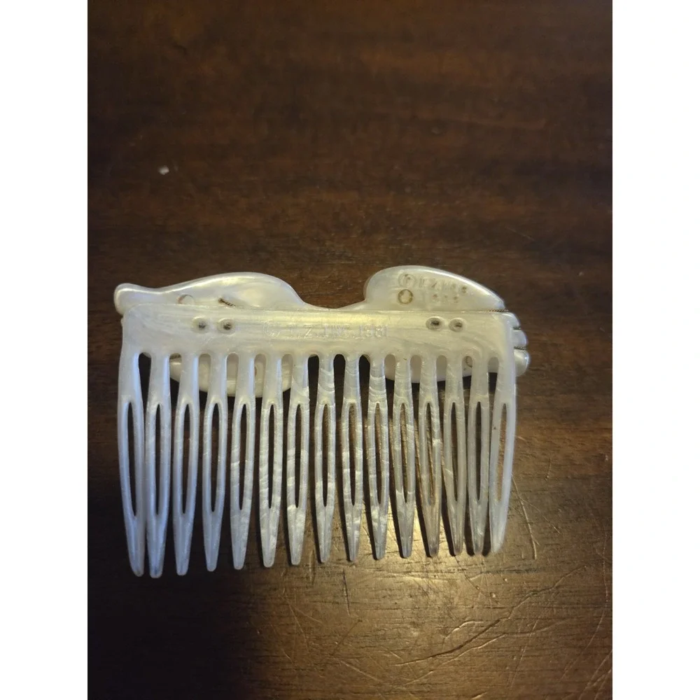 T.Z. Inc. 1981 vintage hair comb is made of faux mother-of-pearl cellulose...